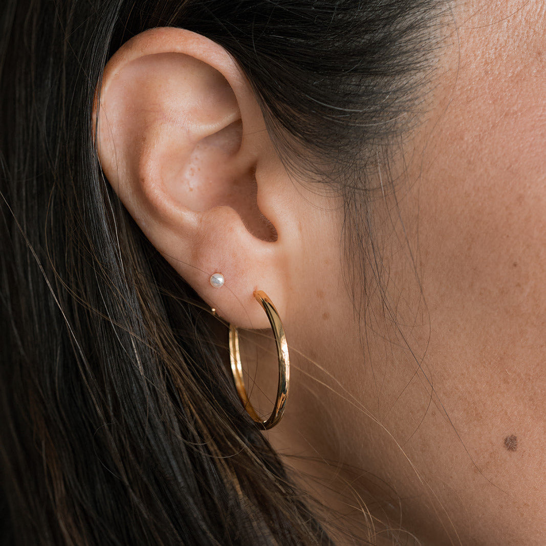 Close up of woman wearing medium size gold hoop