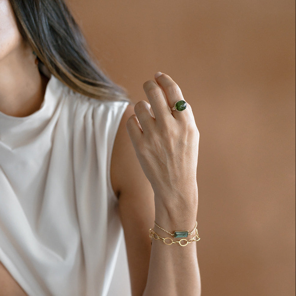 Close up of woman wearing green tourmaline ring