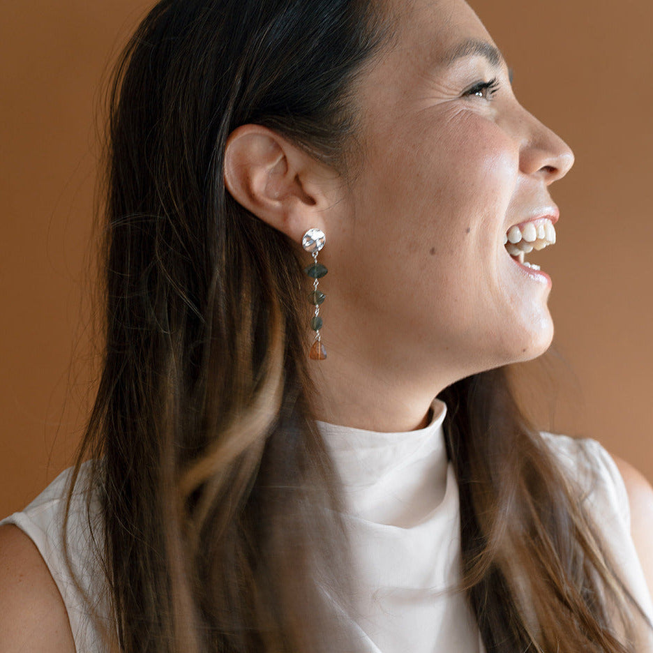 Woman wearing cream tank with labradorite and hessian garnet statement earring set in silver
