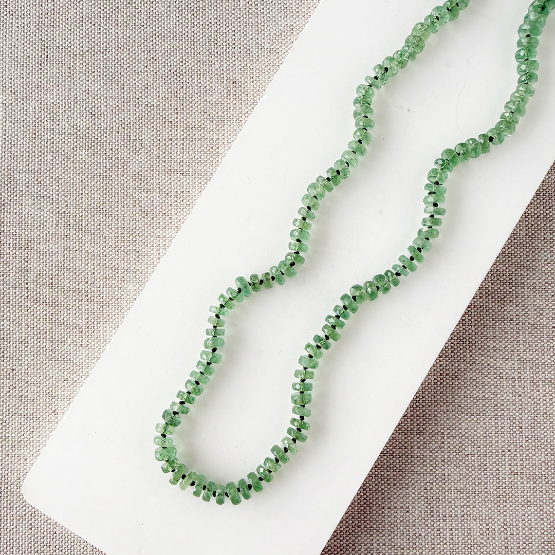Green Kyanite knotted necklace on a white dish with a neutral background