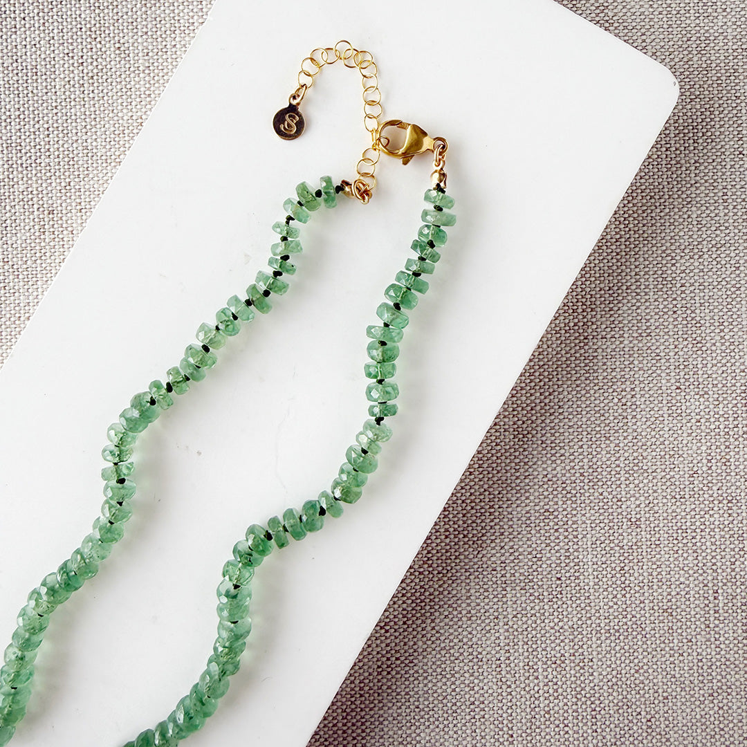 Green Kyanite knotted necklace on a white dish with a neutral background