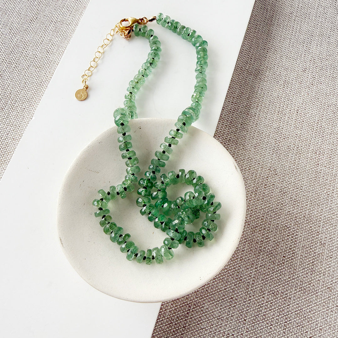 Green Kyanite knotted necklace on a white dish with a neutral background