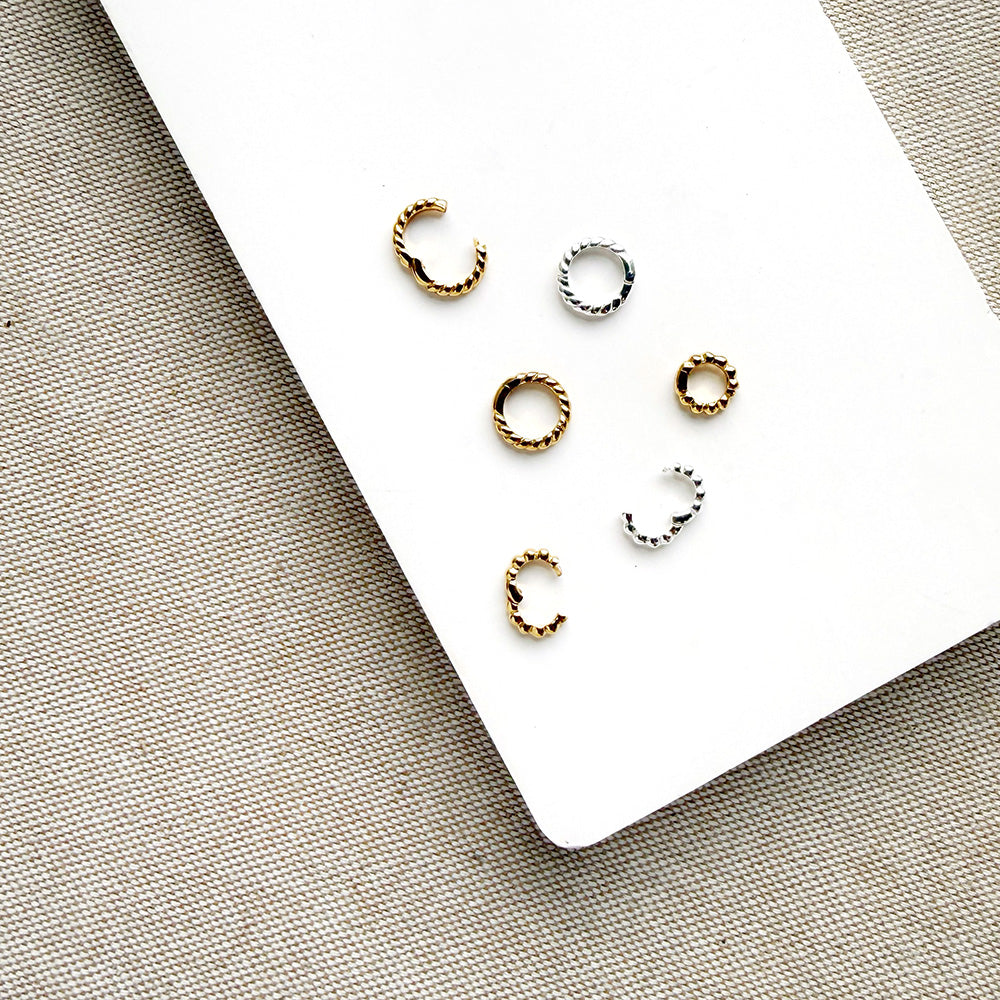 Charm ring enhancers in silver and gold on a white background