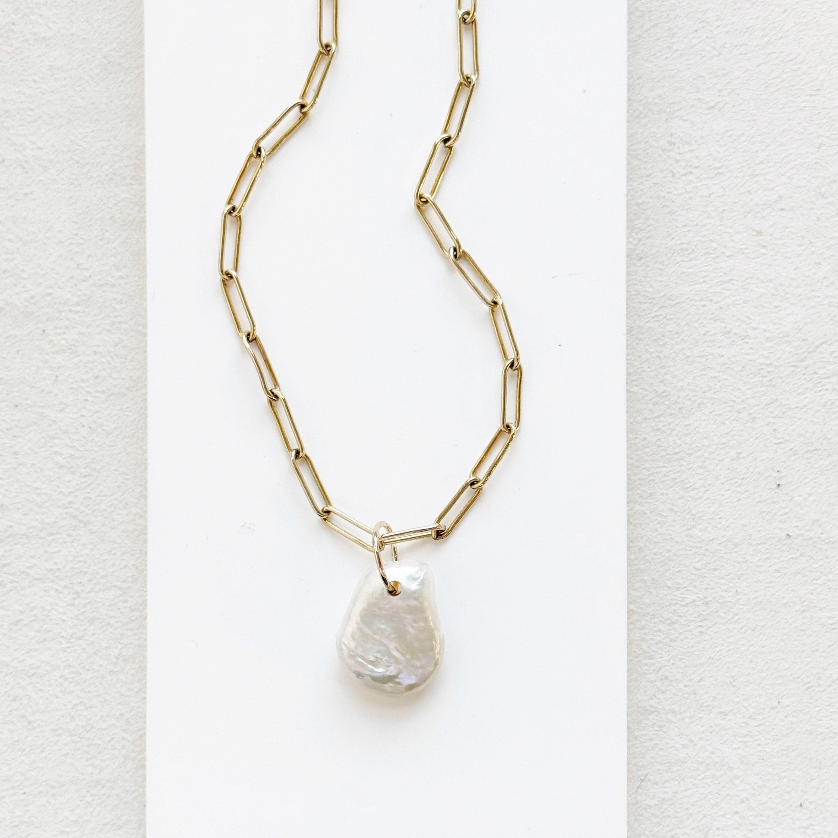 Keshi pearl charm with large gold ring on a gold paperclip chain