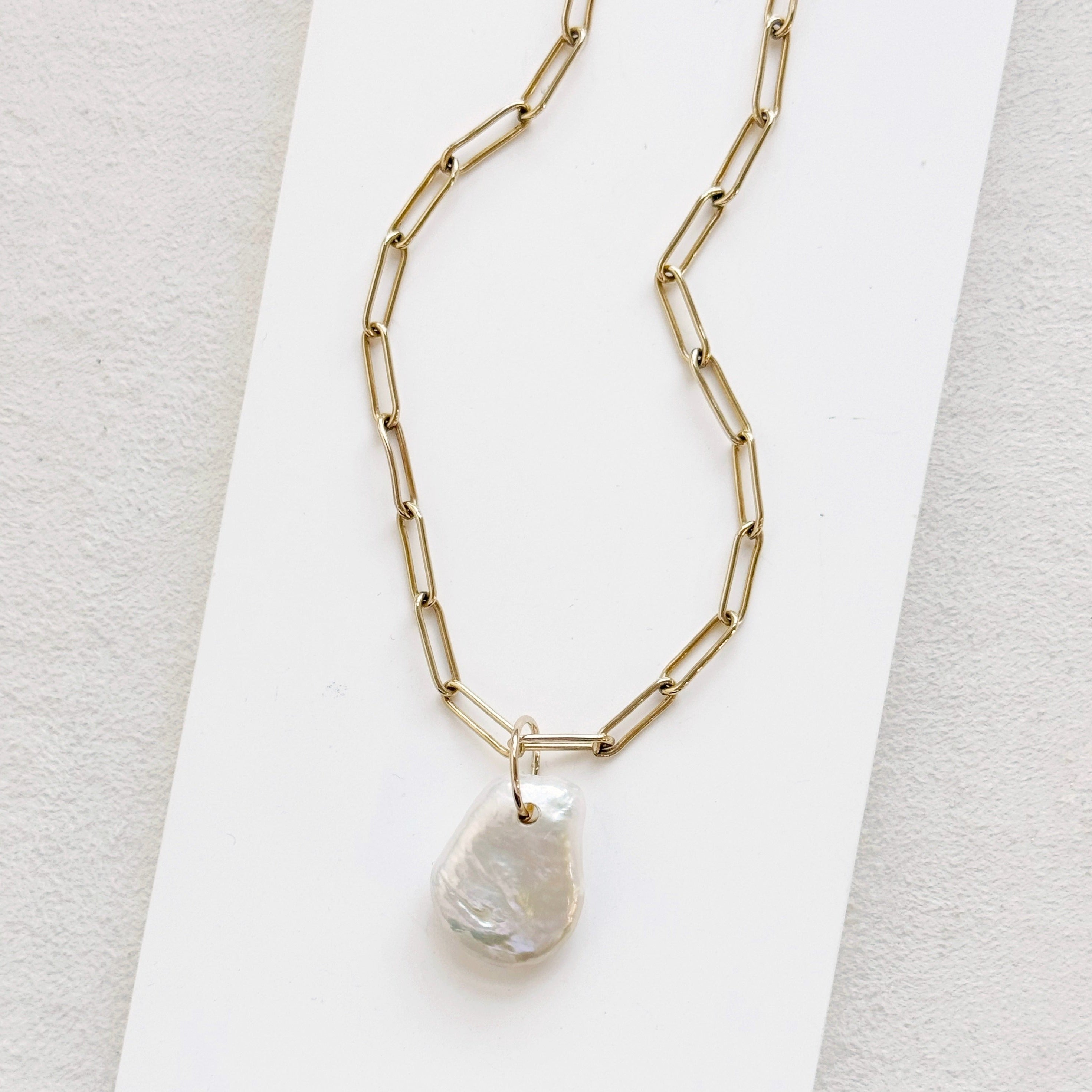 Keshi pearl charm with large gold ring on a gold paperclip chain
