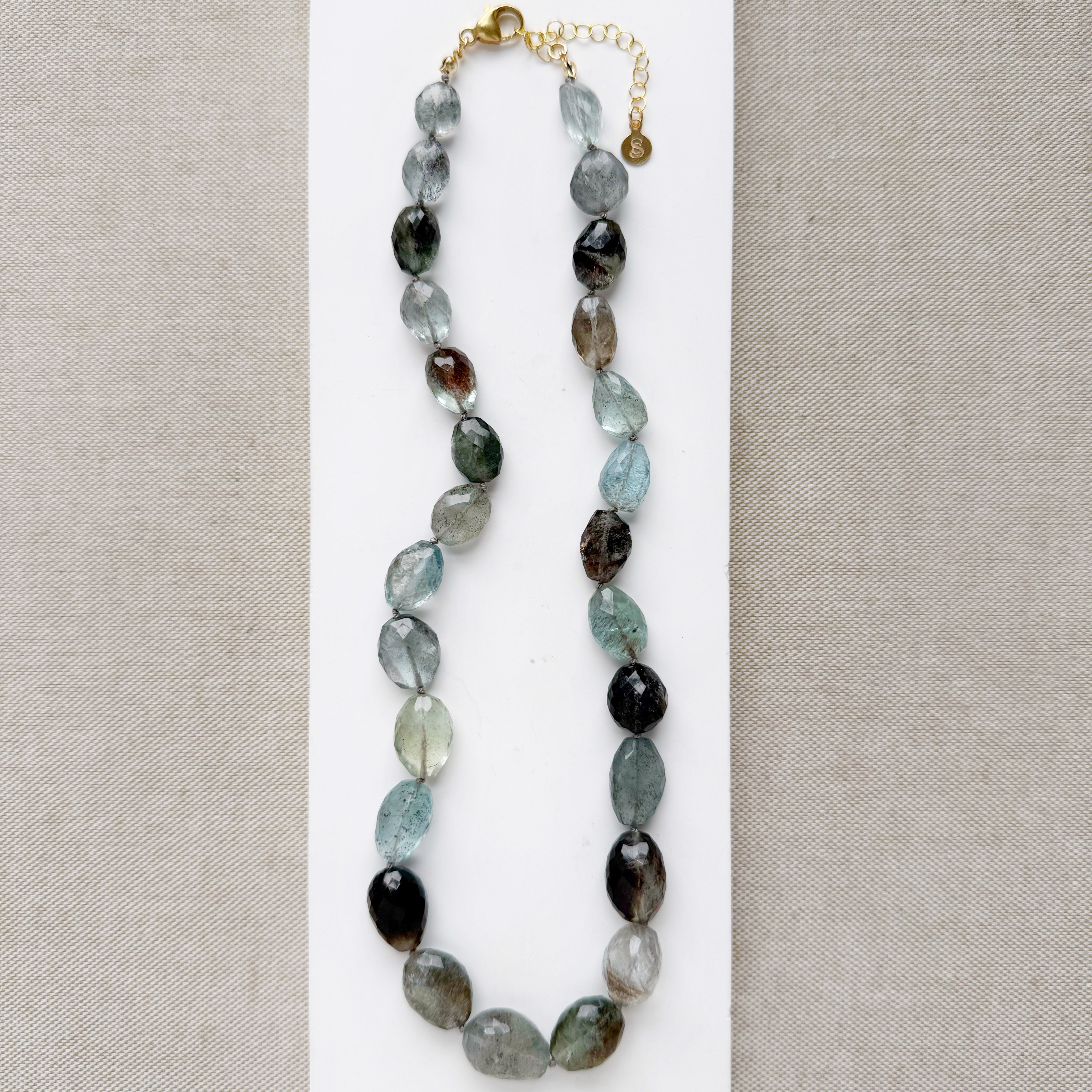 Copper aquamarine necklace on a white plate