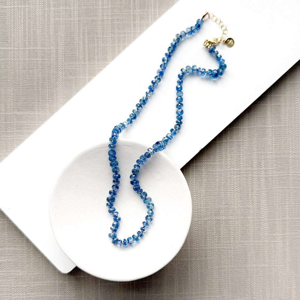 Blue kyanite knotted gem necklace in a white dish