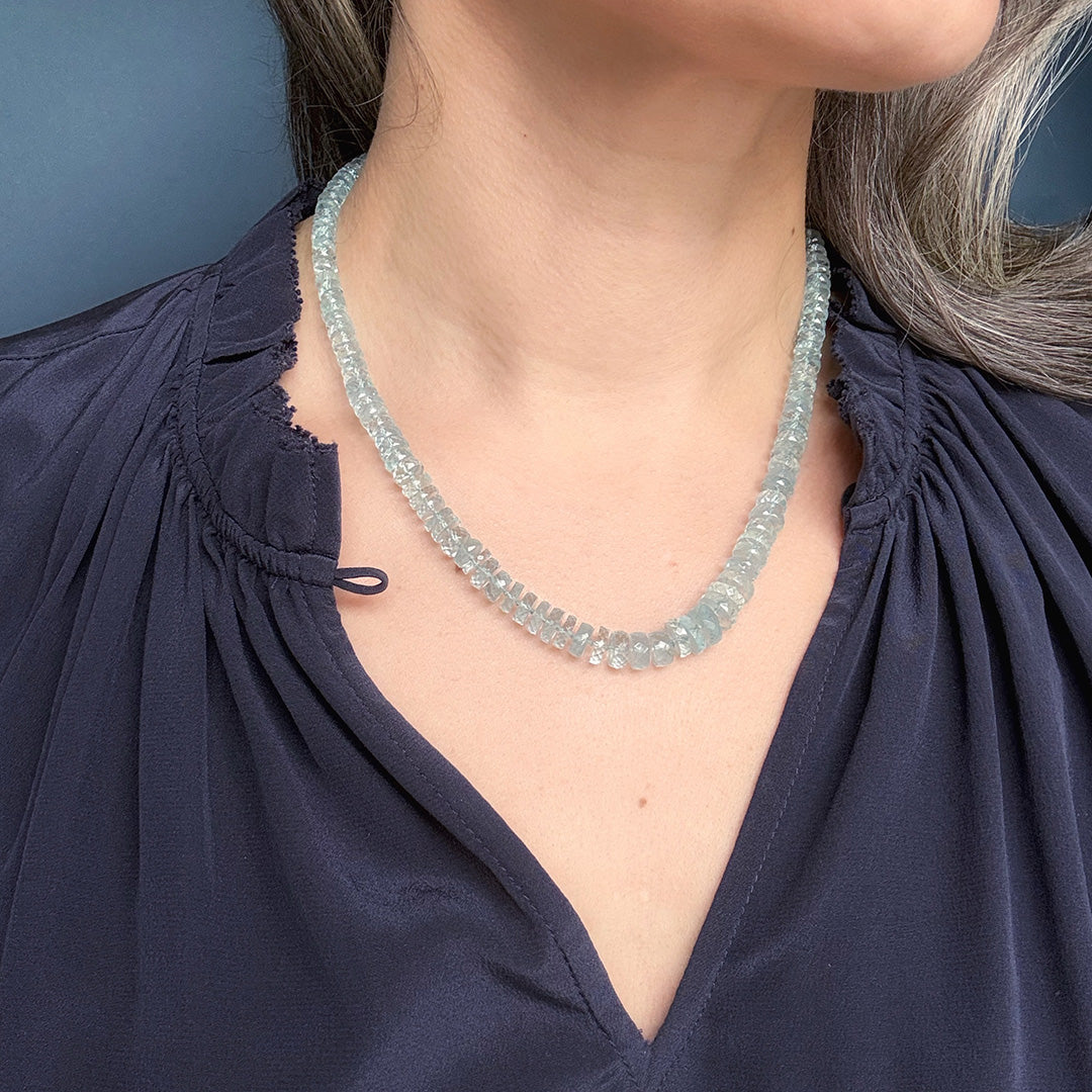 Close up of woman wearing a knotted aquamarine necklace