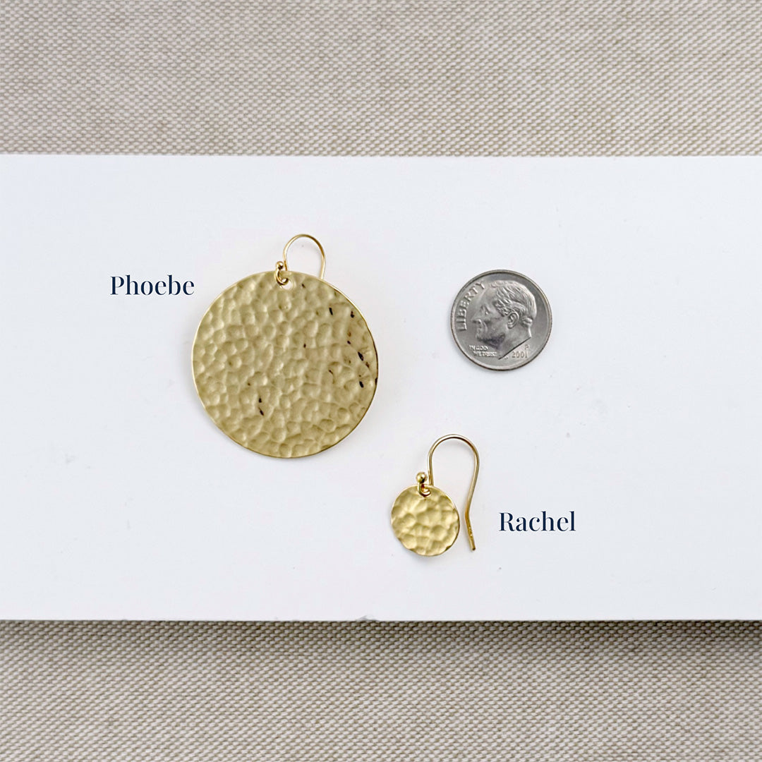 Gold earrings labeled 'Phoebe' and 'Rachel' next to a dime for size comparison on a white background.