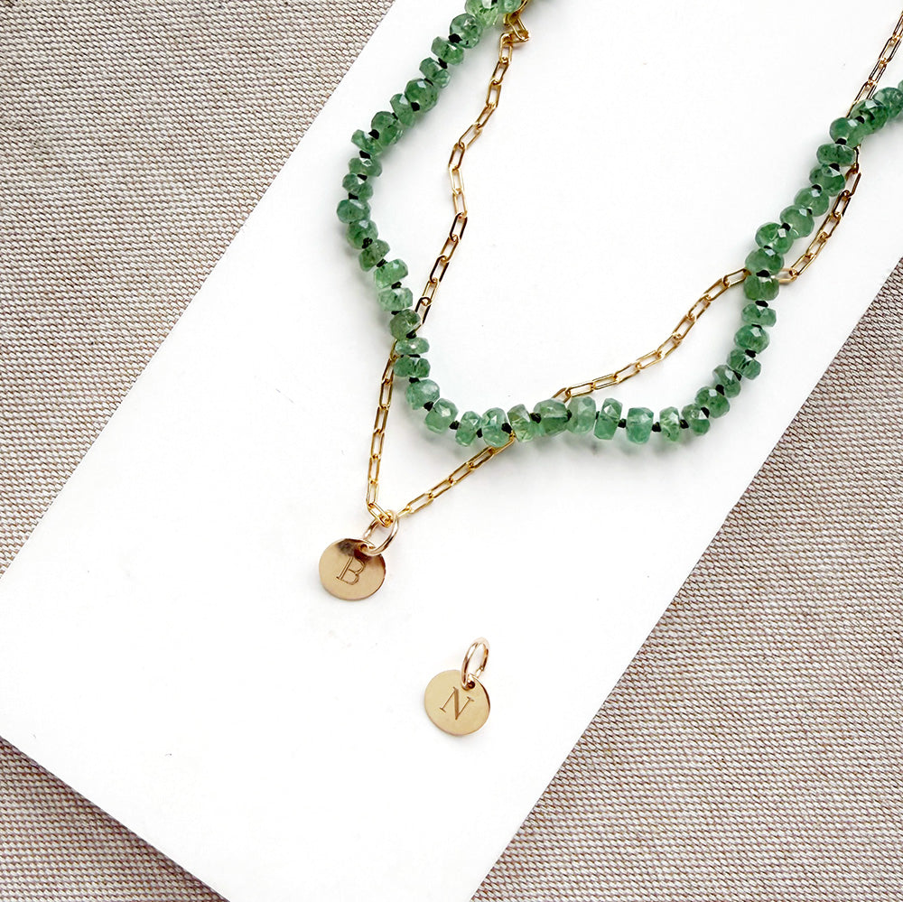 Engraved initial disc charm on a gold chain