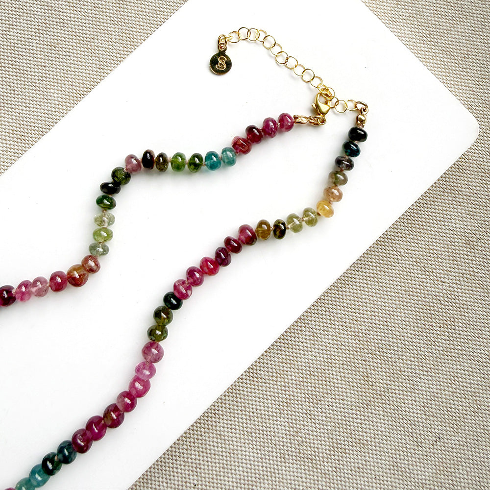 Clasp detail of necklace with smooth Watermelon Tourmaline in shades of pink, red, green, blue, and orange, featuring a small green tourmaline charm