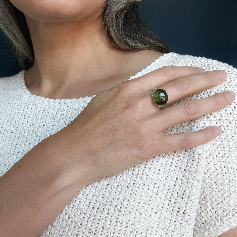 Woman wearing a green tourmaline mixed metal ring