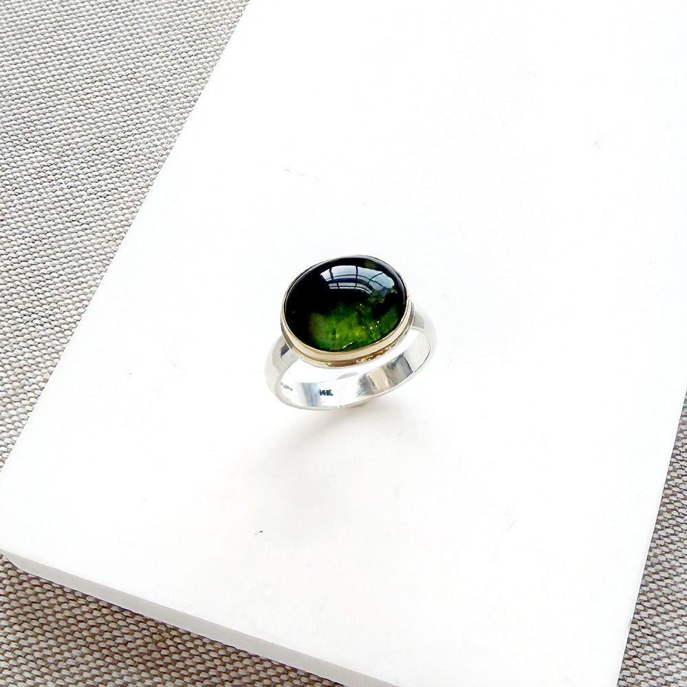 Green Tourmaline mixed metal ring on a white background