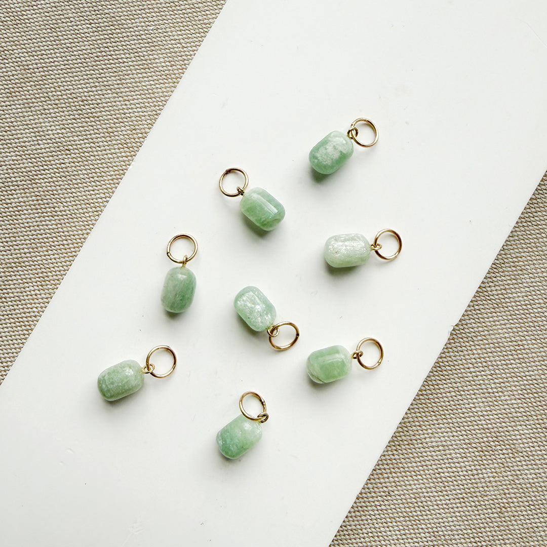 Jade charms in a cylinder cut on a white plate
