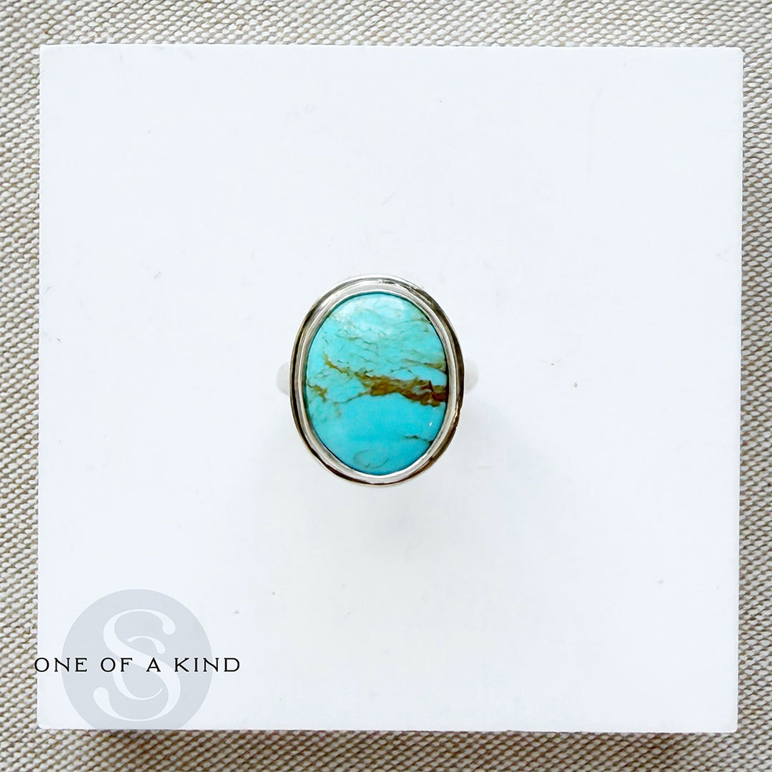 Turquoise stone ring on a white card with 'One of a Kind' branding.