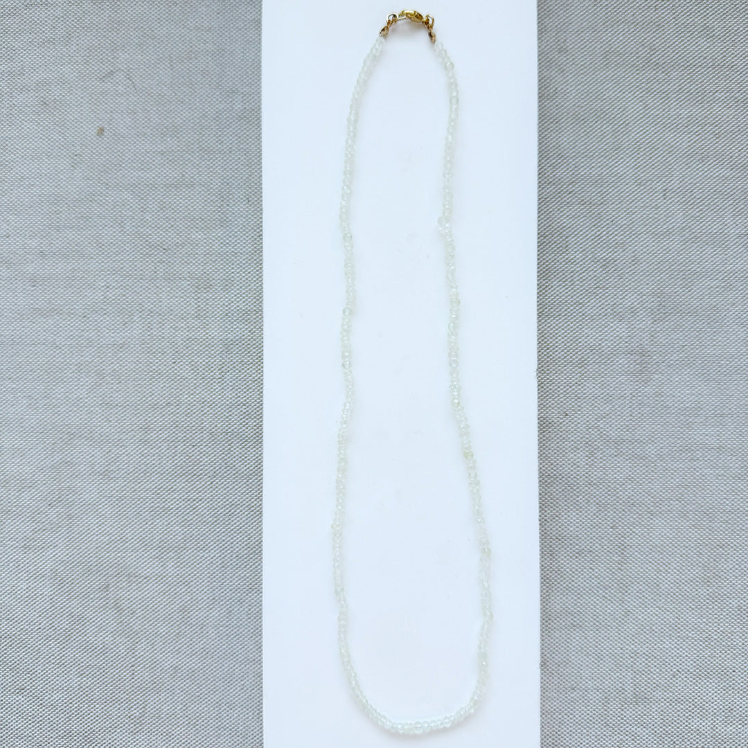 lemon quartz gem necklace on a light gray fabric background