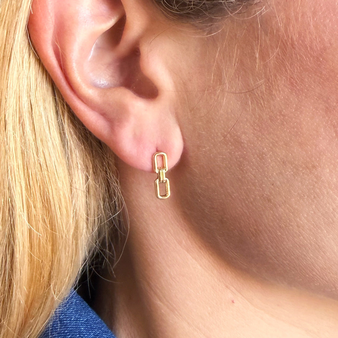 Close up of woman wearing a chain link stud in gold