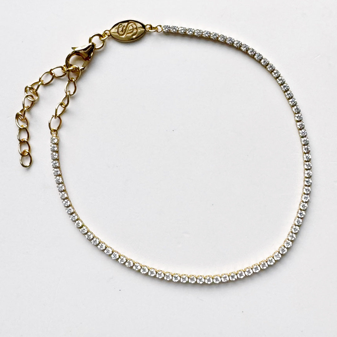 Gold and CZ micro style tennis bracelet on a white background