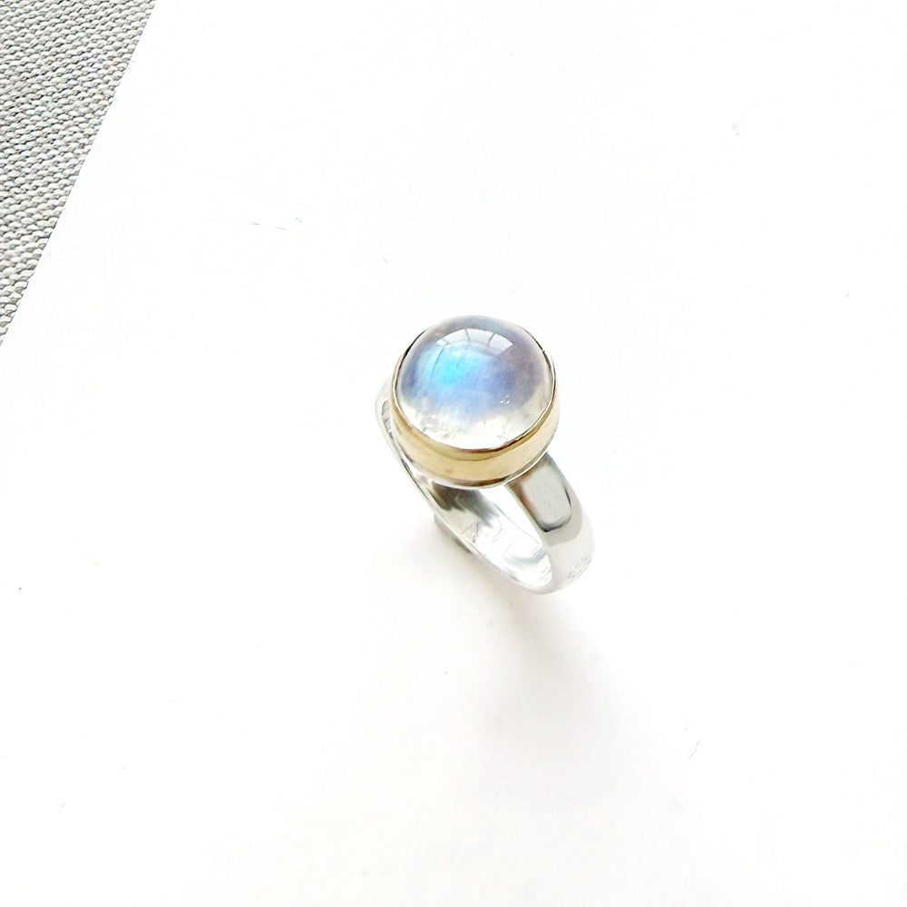 Round moonstone mixed metal ring on a white background