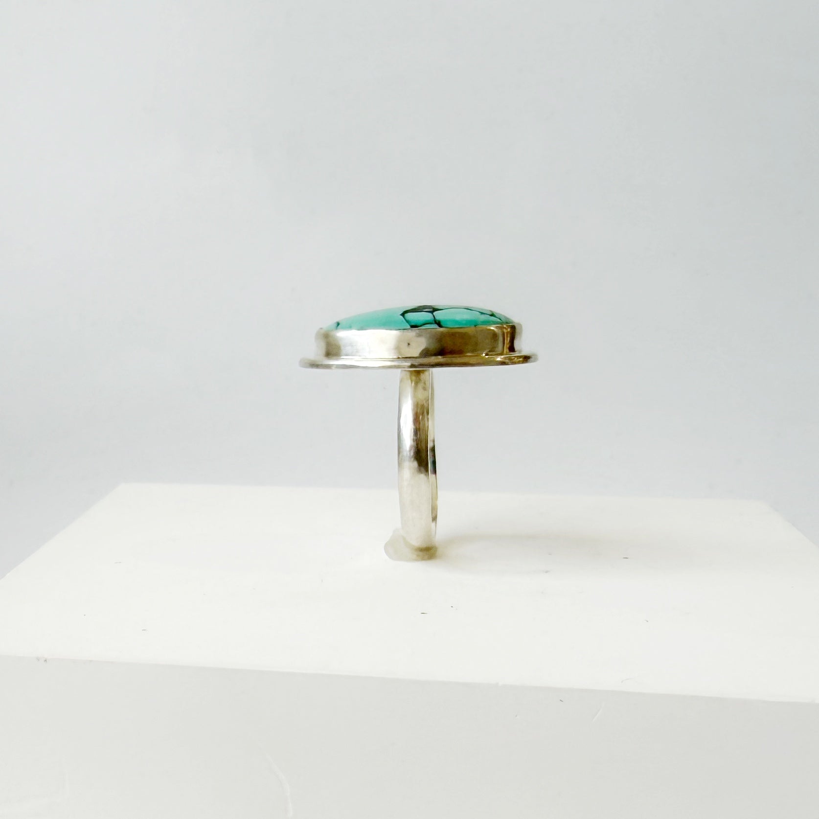 Side view of Nevada turquoise ring on a white background