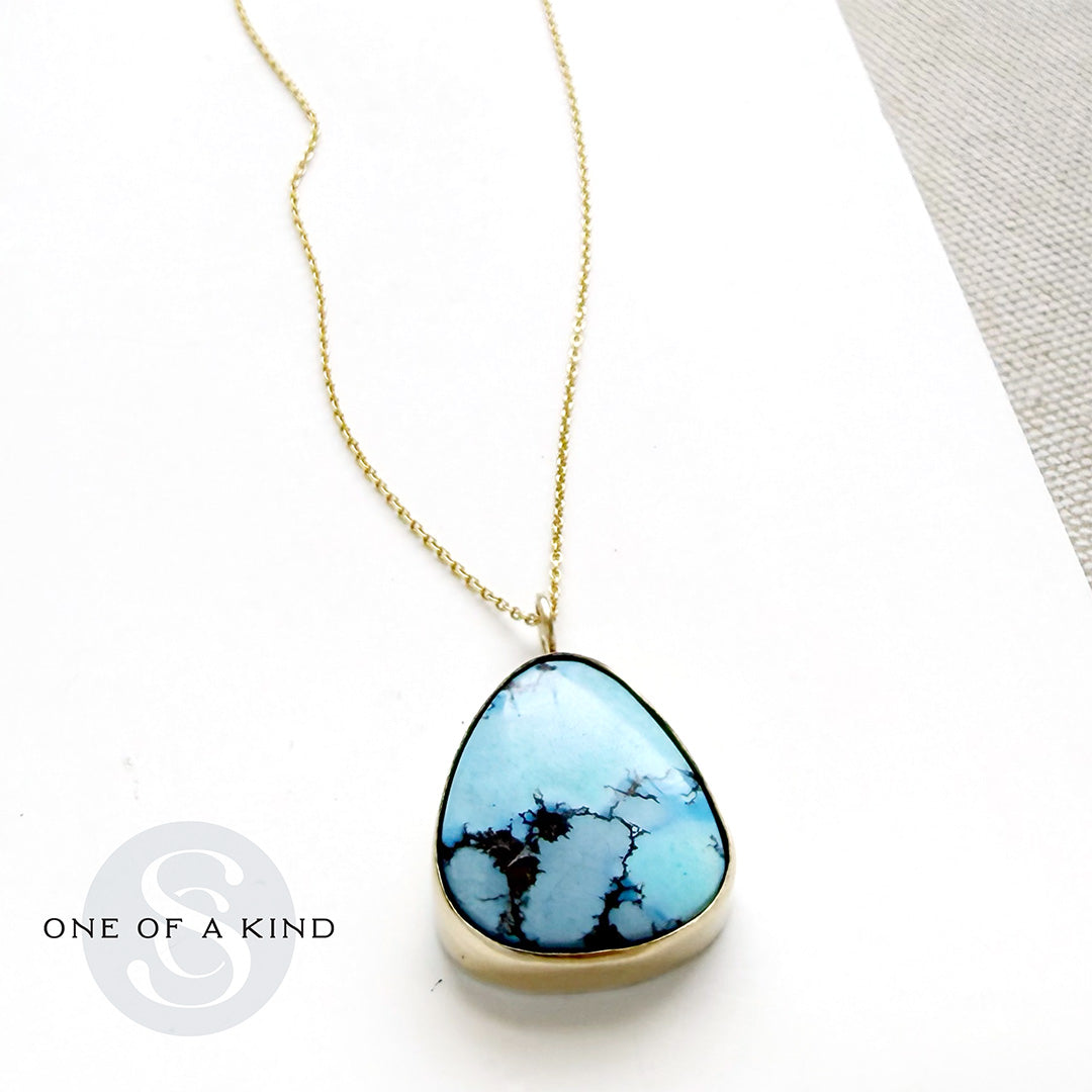 Golden Hills turquoise pendant necklace in solid gold on a white background with one of a kind branding