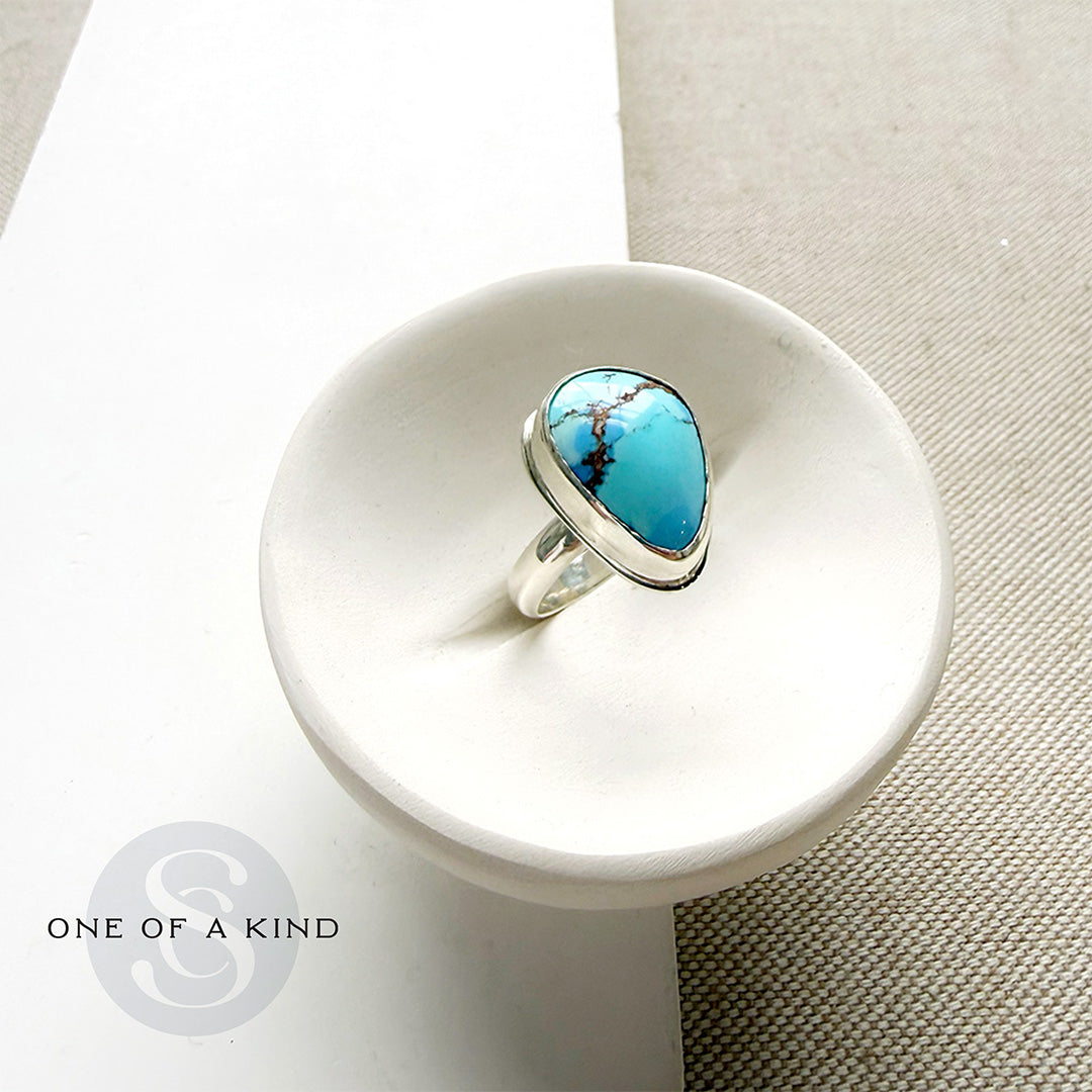 One of a kind Golden Hills Turquoise silver ring in a white dish