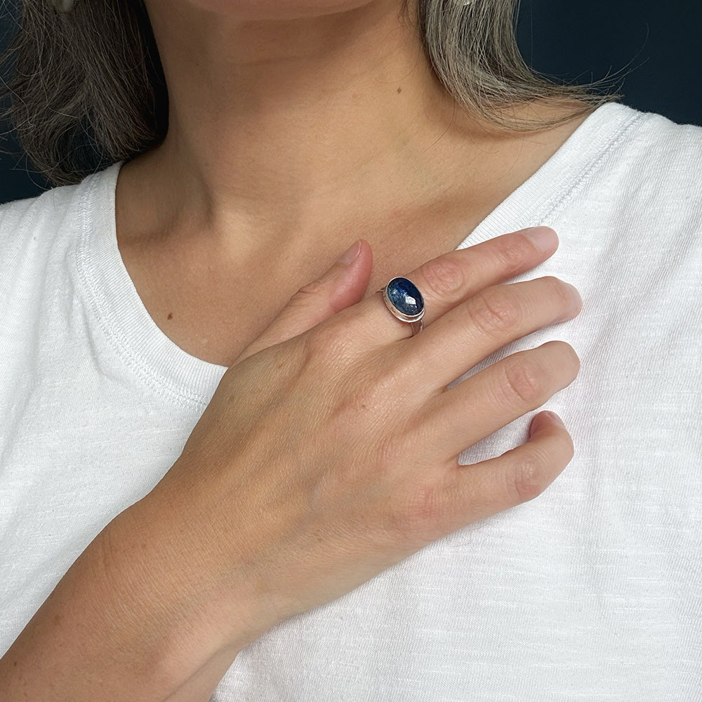Woman wearing smooth cut blue kyanite gemstone ring