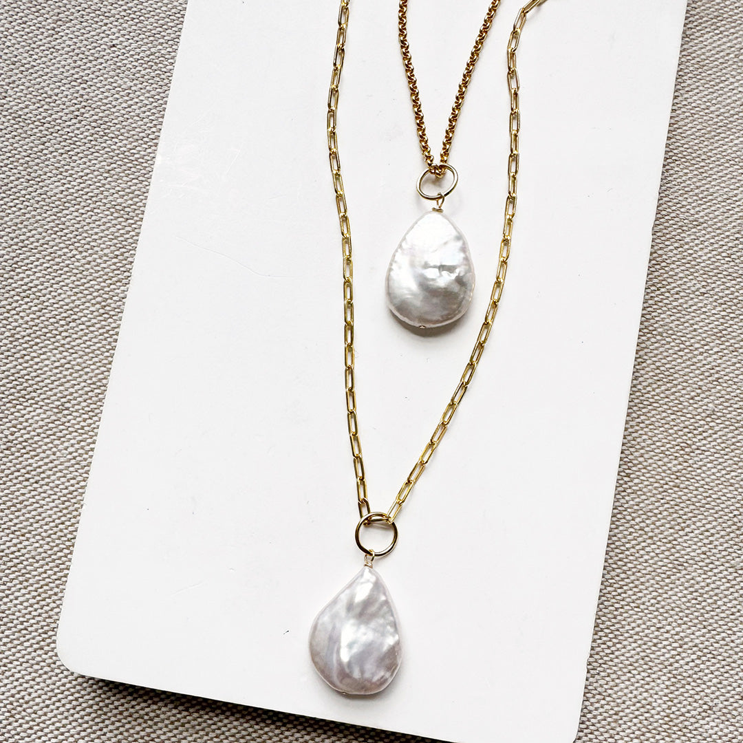 Two gold chains with tear drop shaped pearl charms