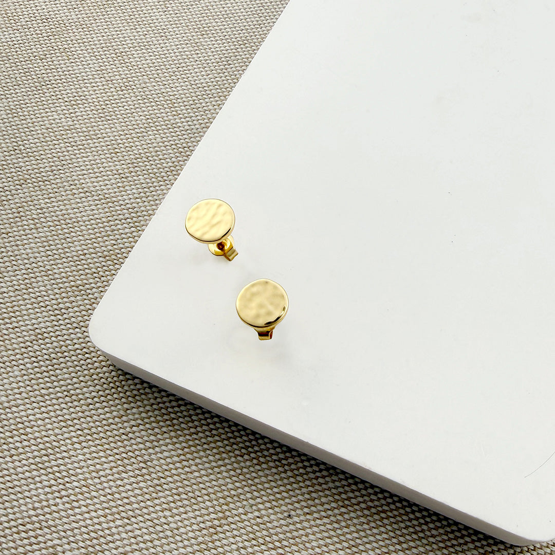Small hammered disc studs in gold on a white background