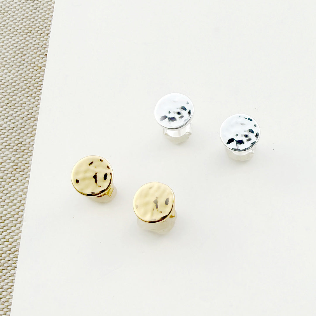 Small hammered disc studs in gold and silver on a white background
