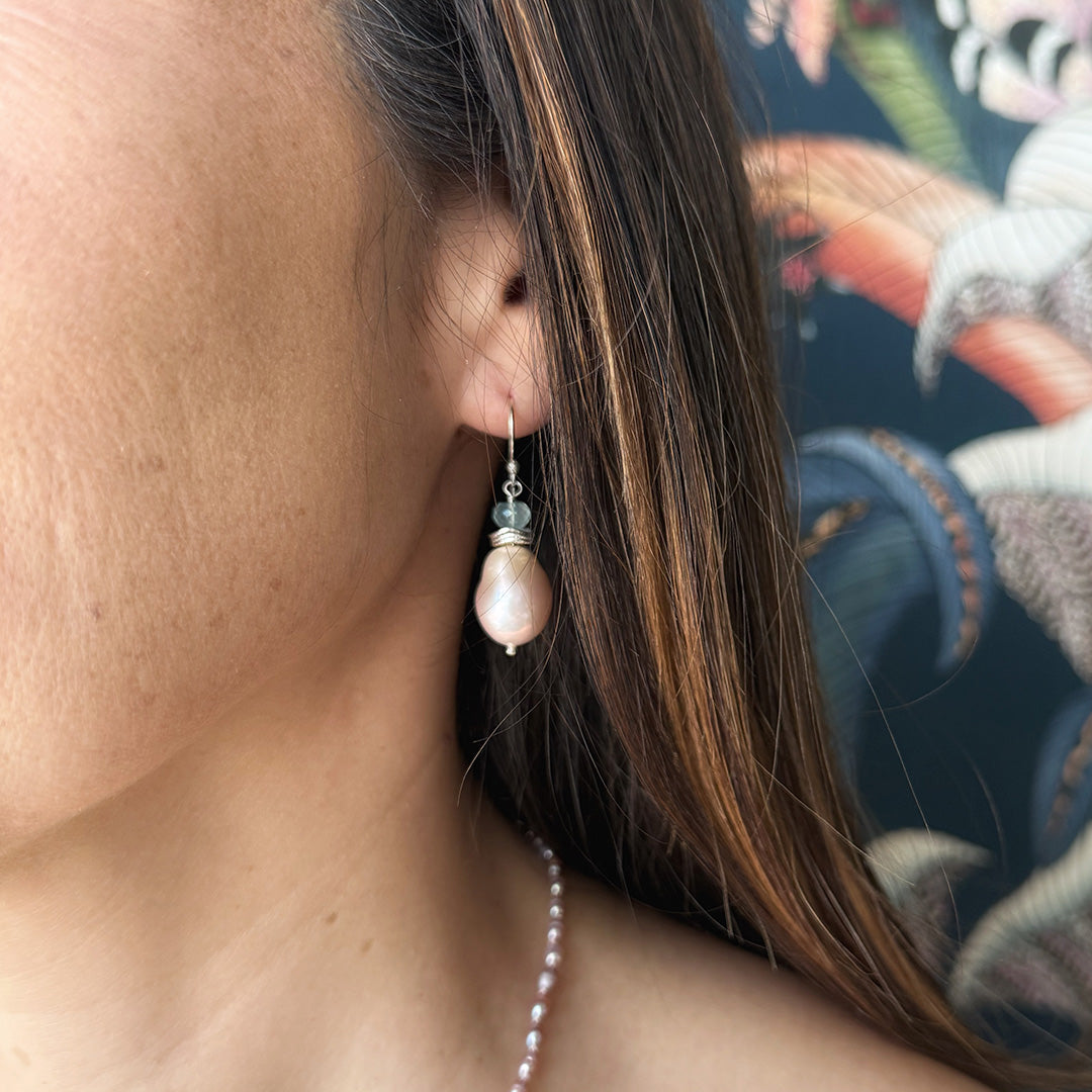 Close up of woman wearing pink pearl drop earring