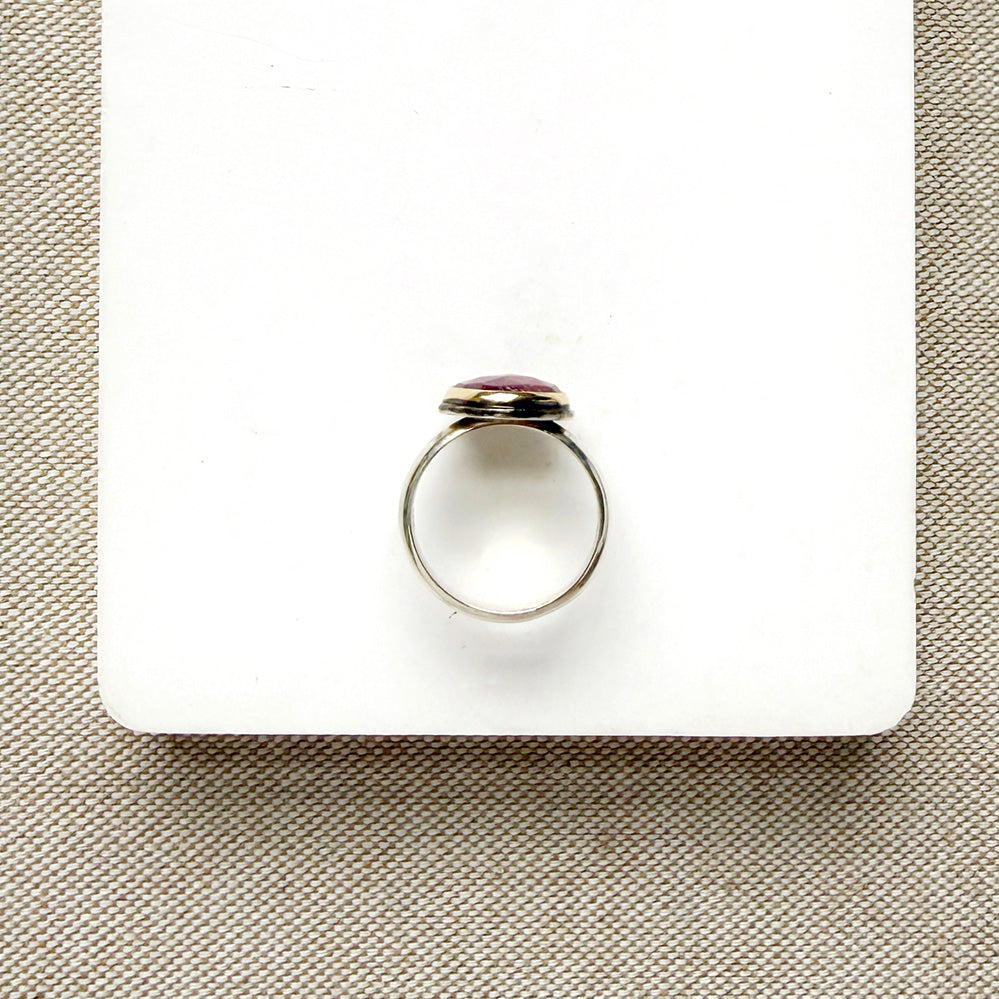 Rose cut pink sapphire mixed metal ring set on a white dish