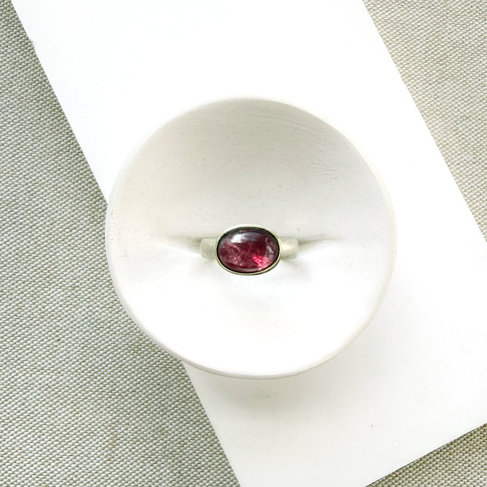 Pink tourmaline mixed metal ring in a dish