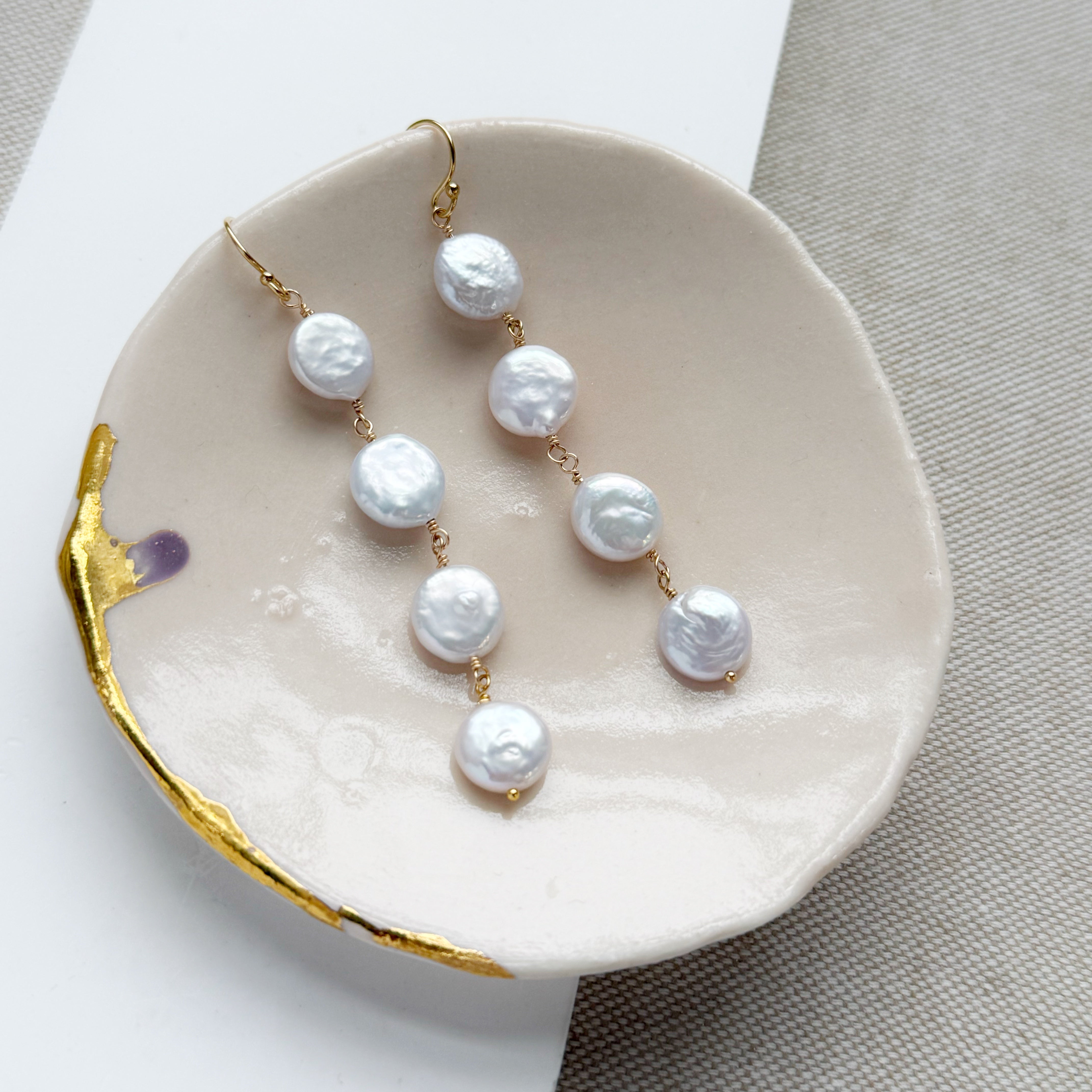 Coin pearl statement earrings in a pale pink dish