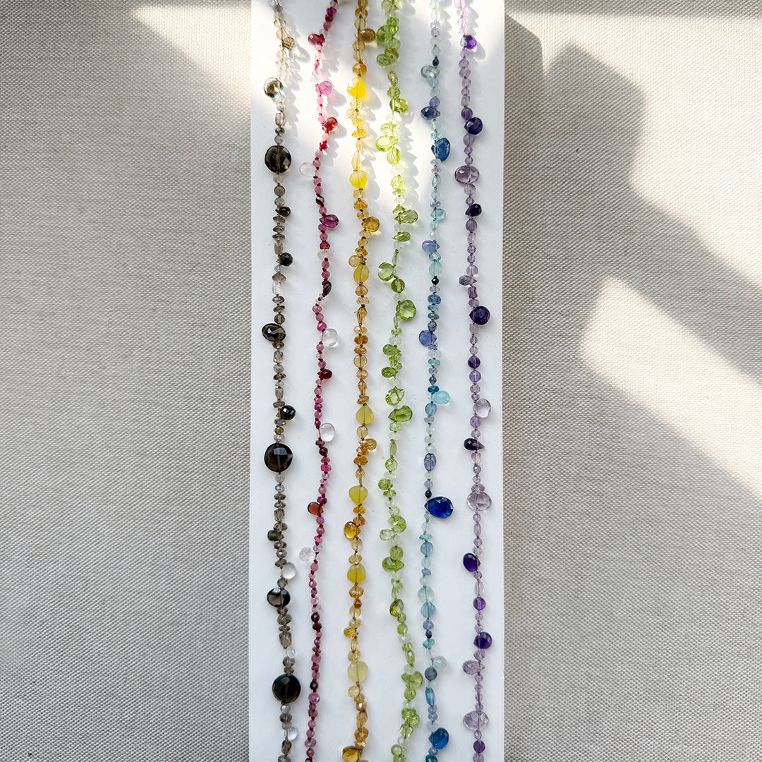 Set of colorful gemstone necklaces on a white background