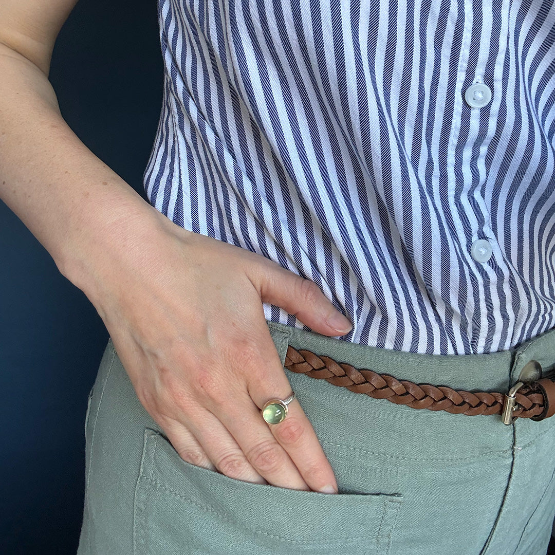 Person wearing a wearing a green prehnite gemstone ring.