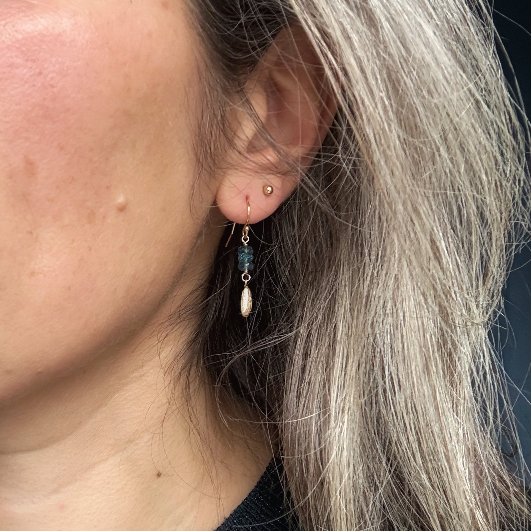 Close-up of a person wearing an earring with gems.