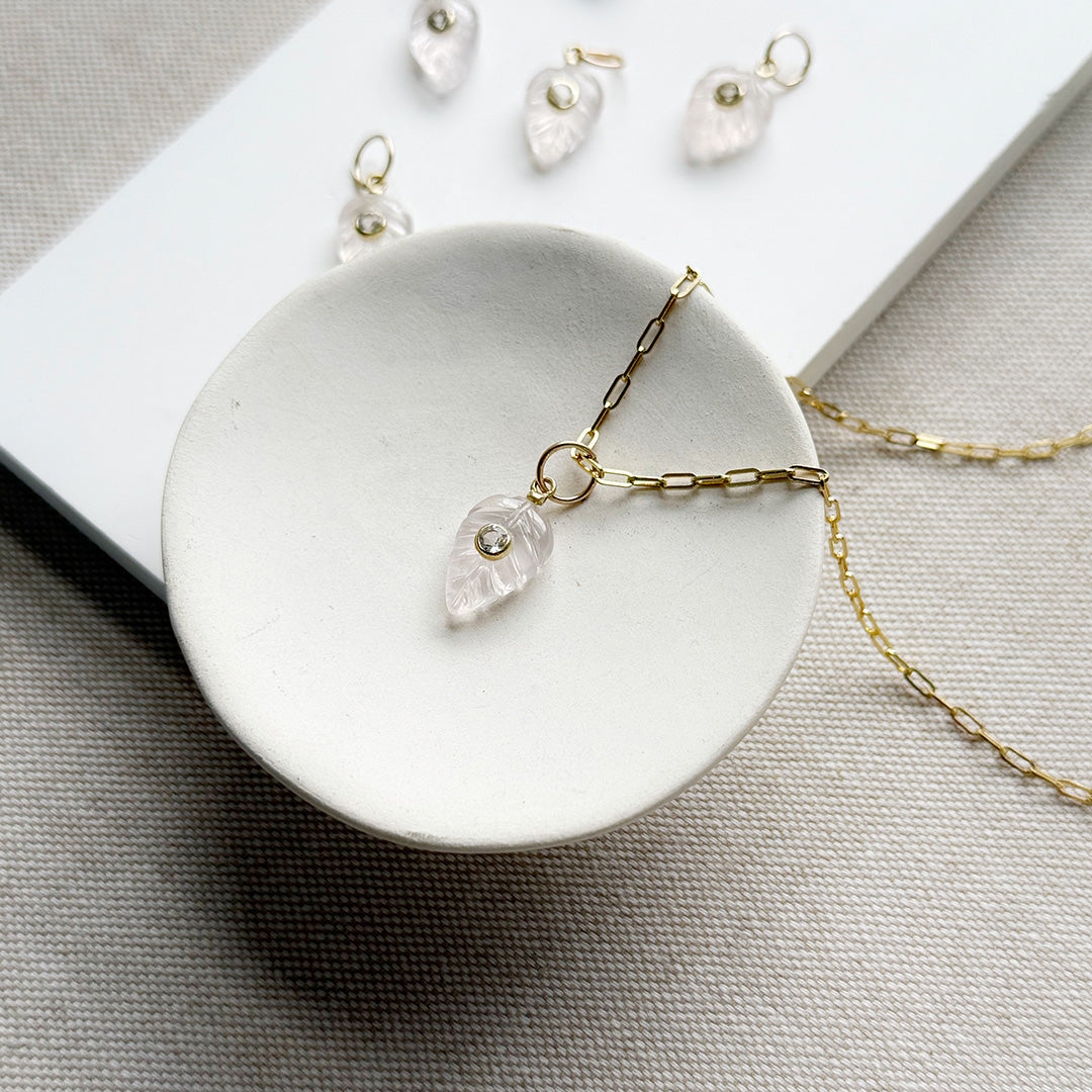 Carved leaf charm in rose quartz on a gold chain