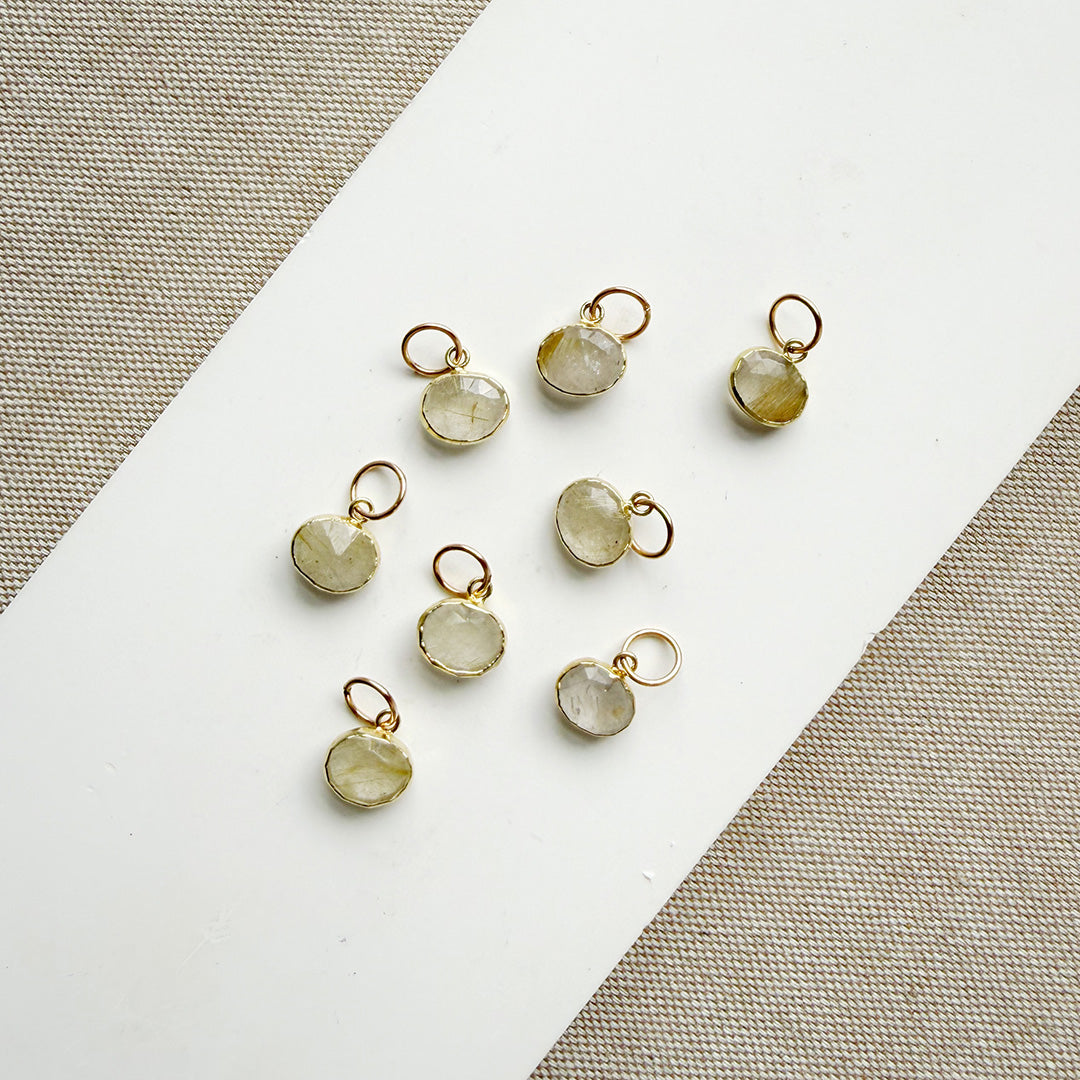 Rutilated quartz charms on a white plate