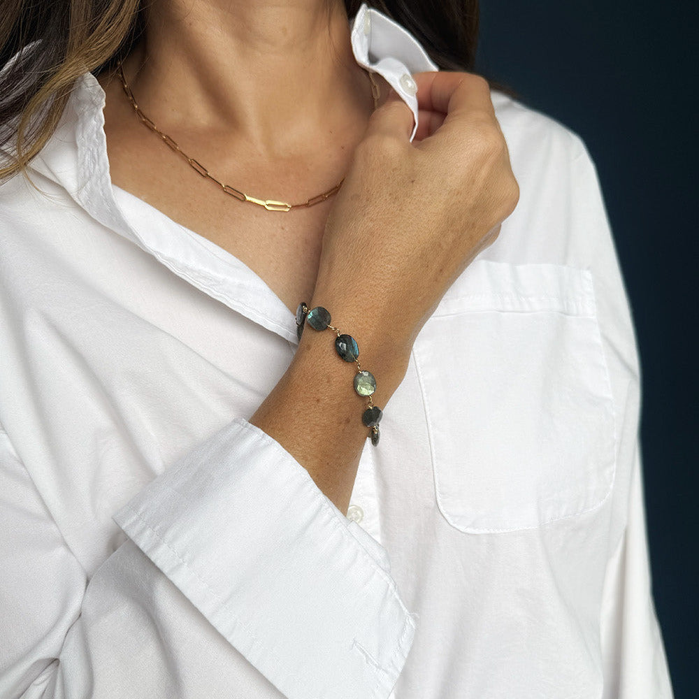 Woman wearing labradorite bracelet with a white shirt