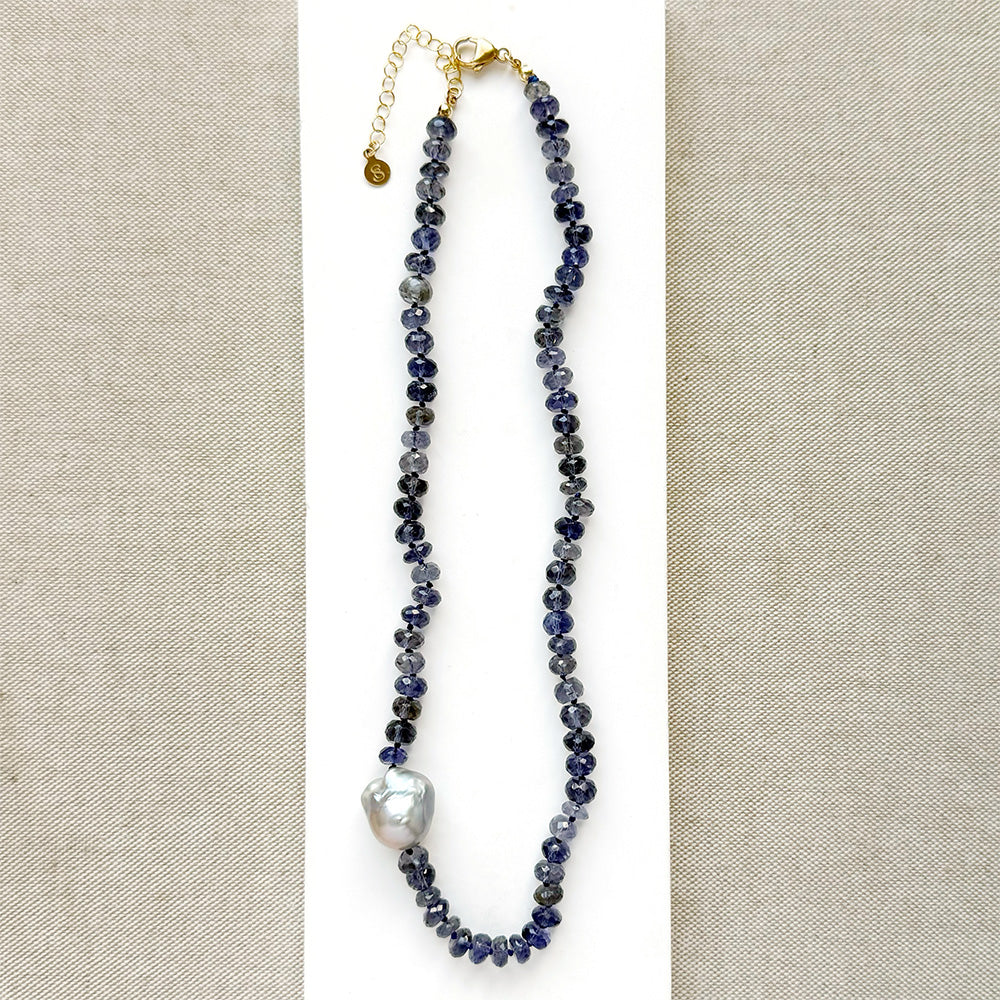 Knotted iolite gemstone necklace with gray baroque pearl on a white card