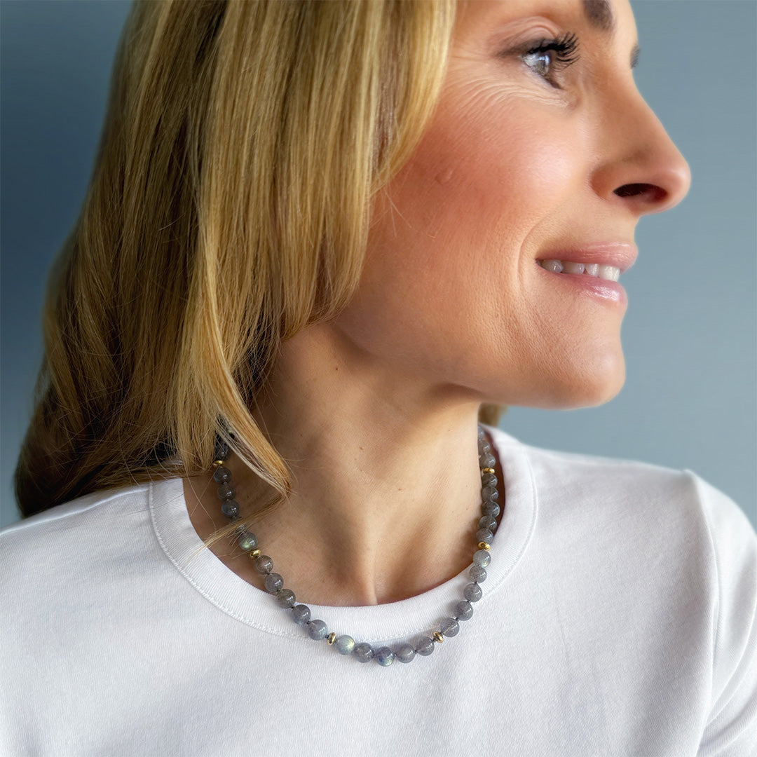Blonde woman wearing round labradorite bead necklace