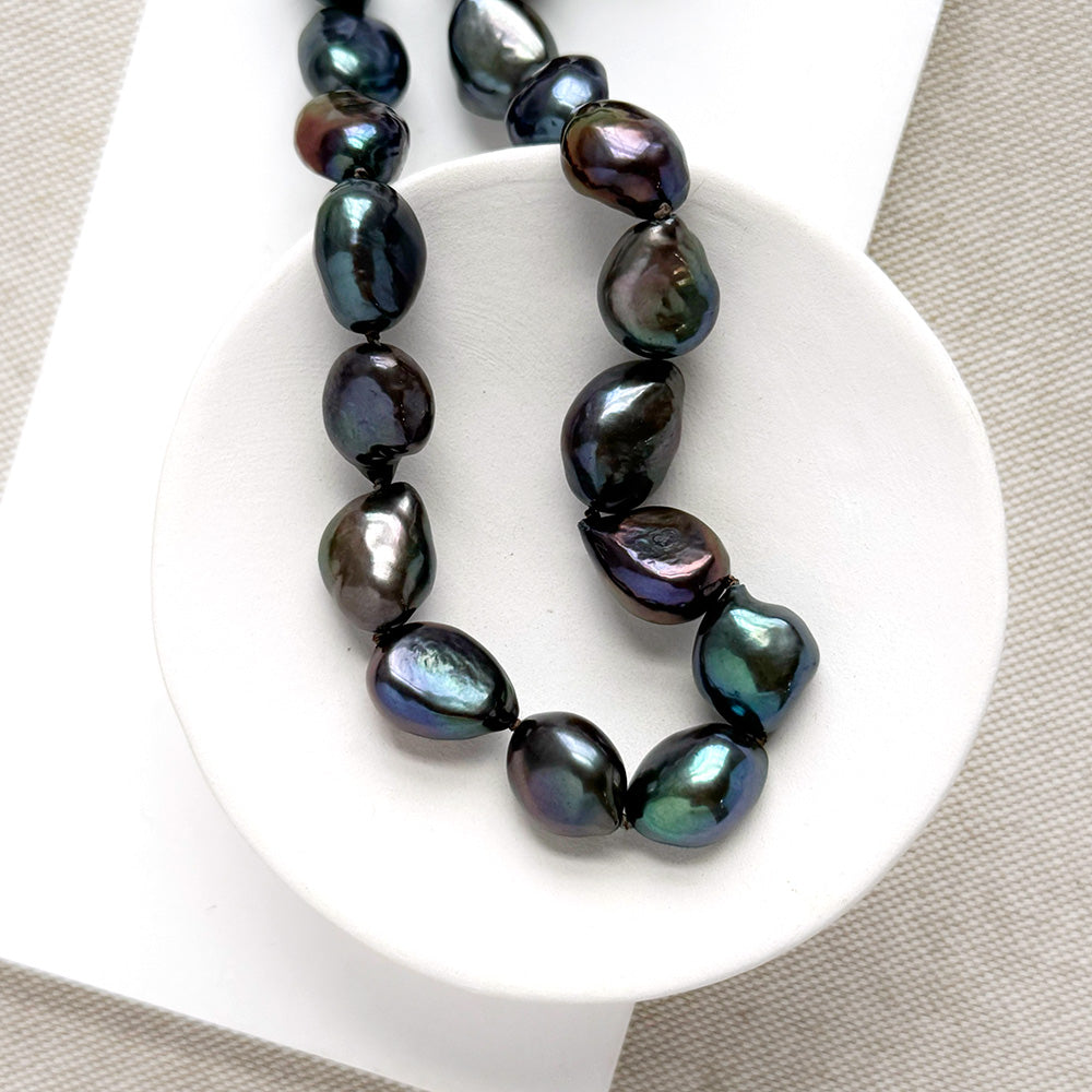 Peacock pearl statement necklace in a white dish