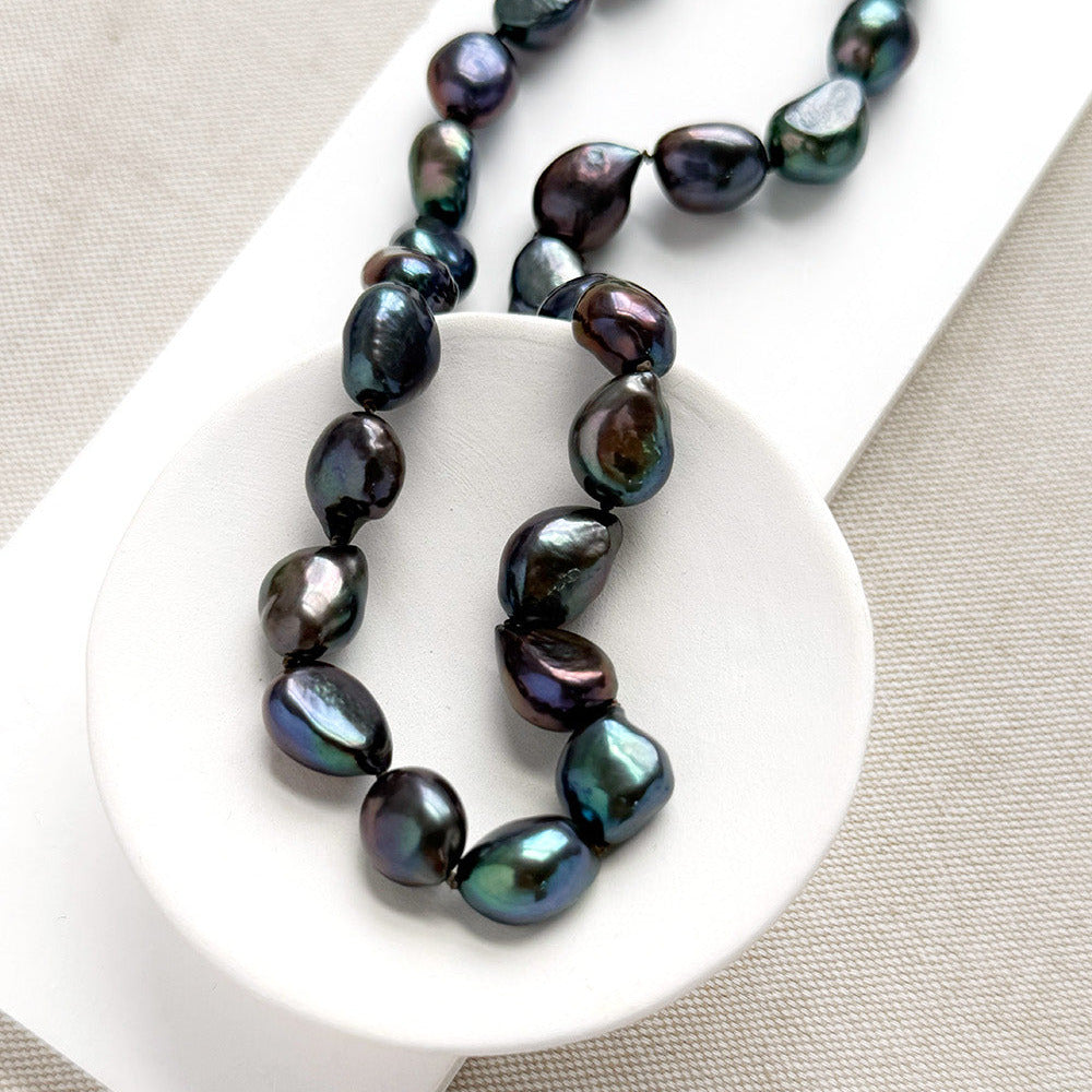 Peacock pearl statement necklace in a white dish