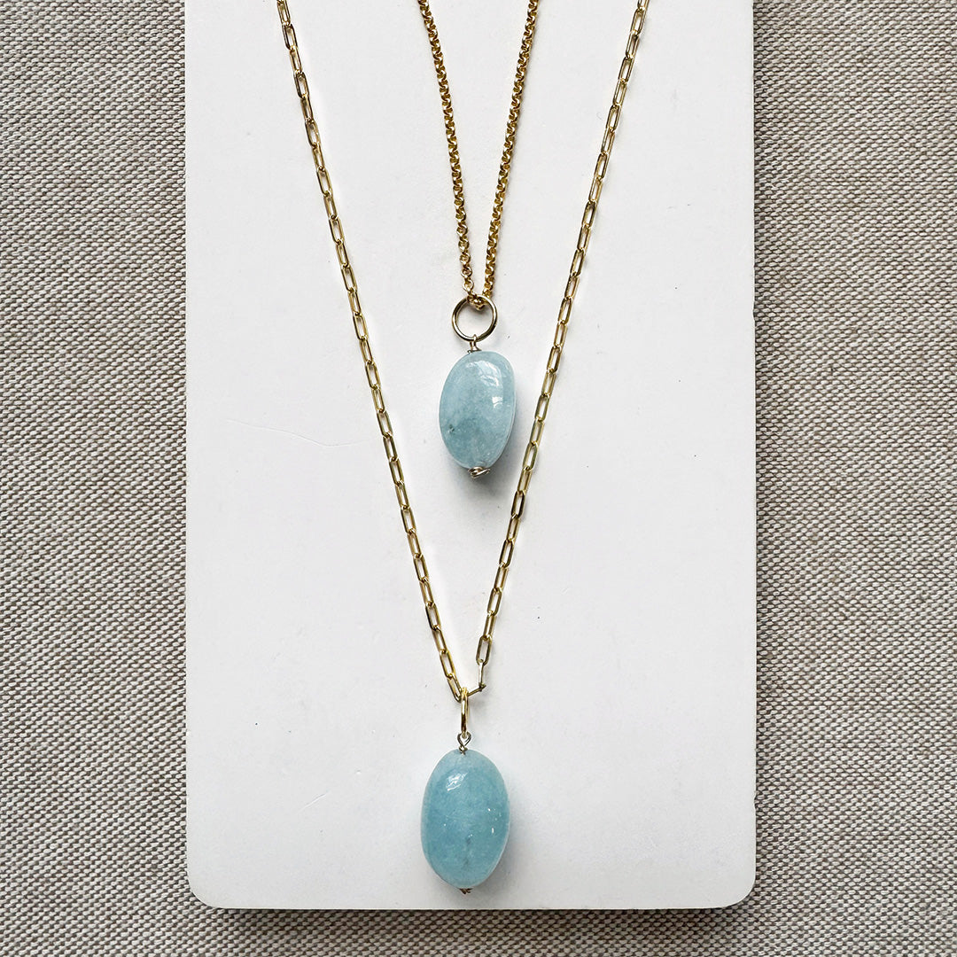 Two gold chains with smooth oval aquamarine charms
