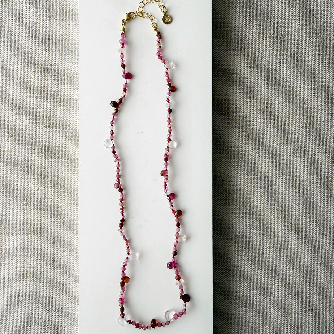 Gemstone necklace in shades of red on a white surface