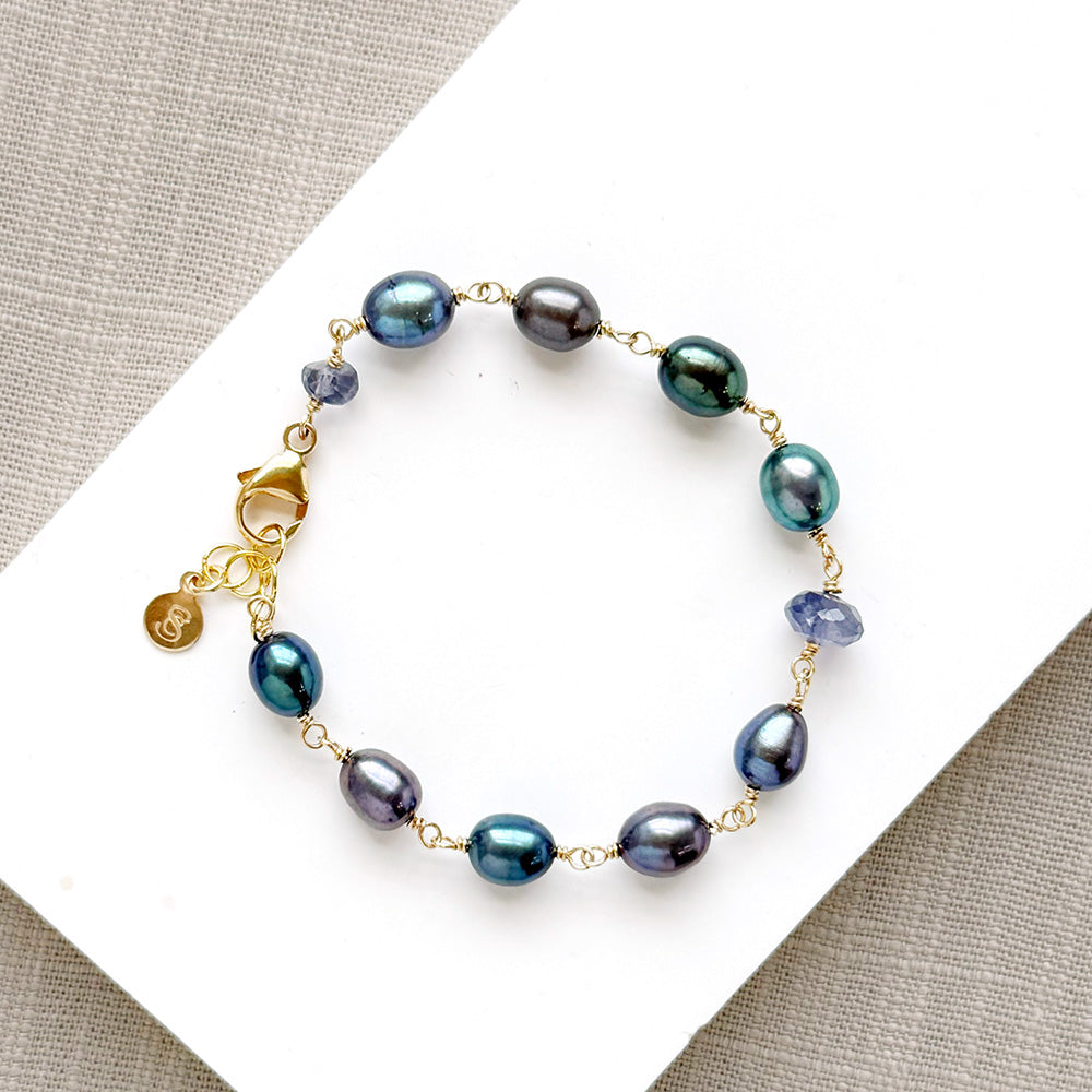 Peacock pearl and iolite bracelet on a white dish