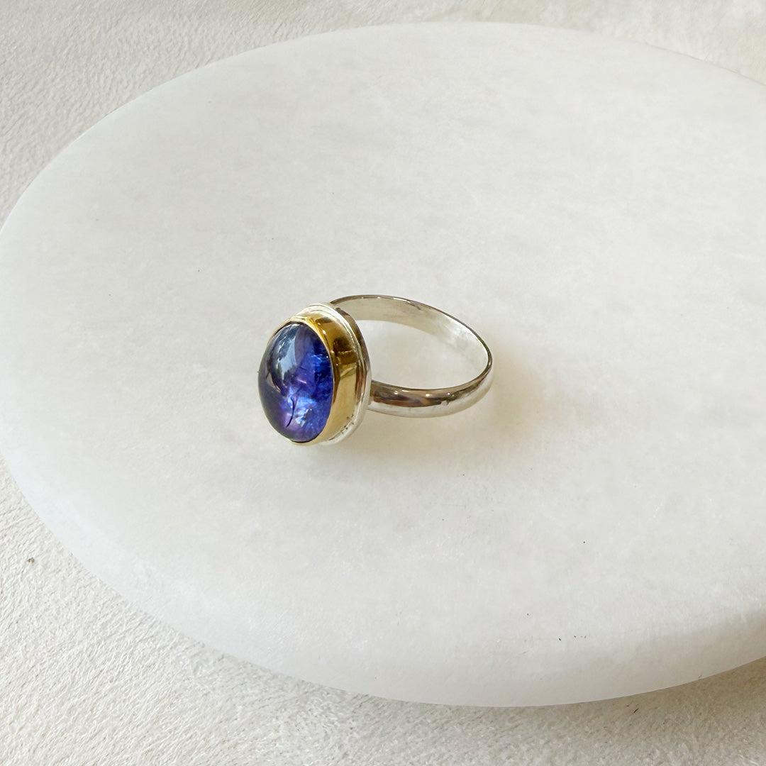 Ring with a purple tanzanite gemstone on a white dish