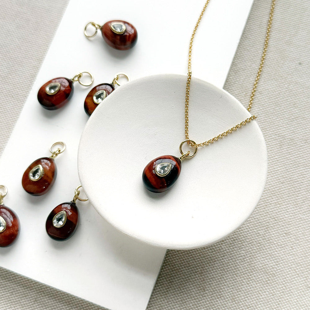 Tiger Eye charm with inset cz stone in a white dish