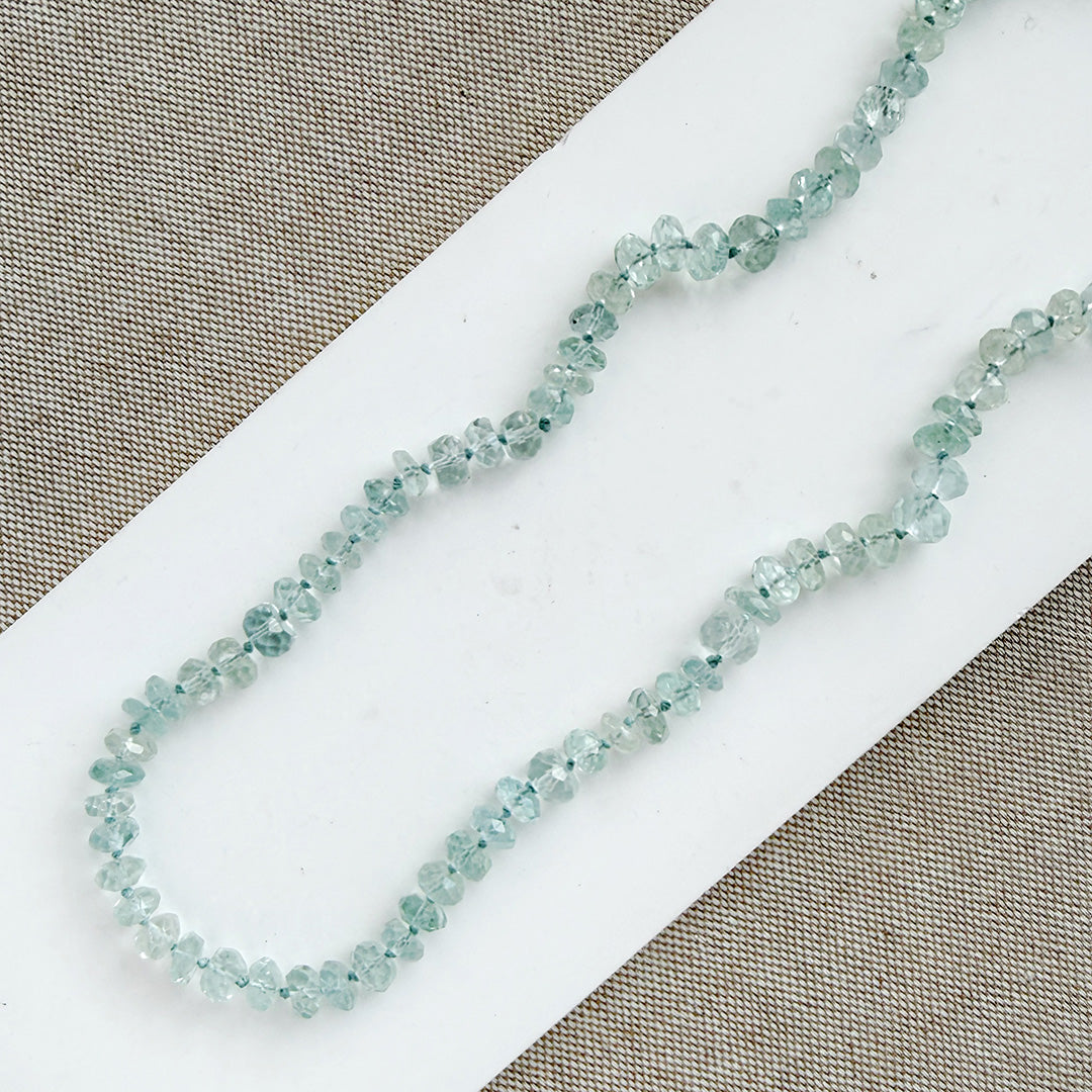 Light blue topaz knotted necklace on a white dish